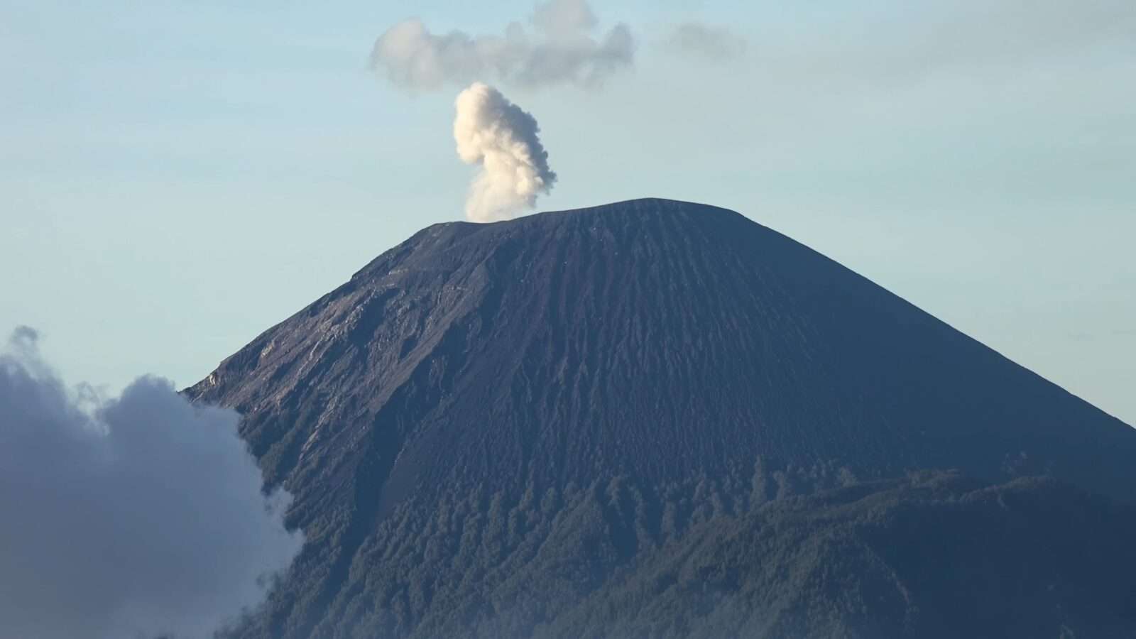 A view of a huge volcano with smoke indicating its explosive activity, Wonders of the World Pictures.