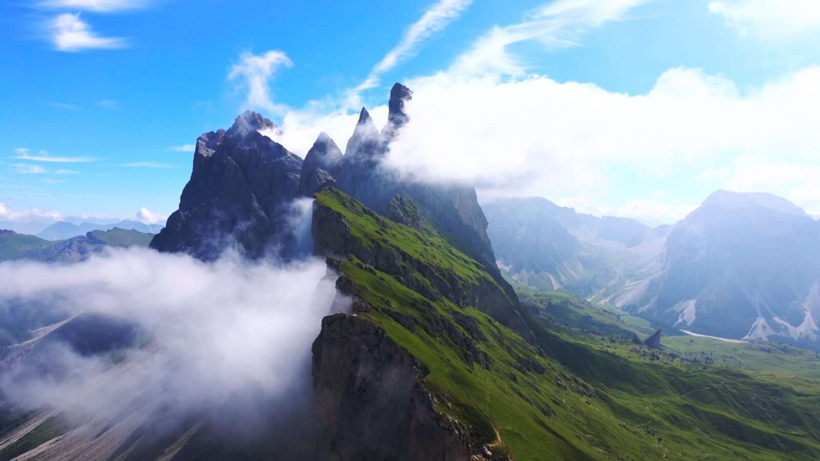 Majestic mountain peaks piercing the clouds against the blue sky, Wonders of the World Pictures.
