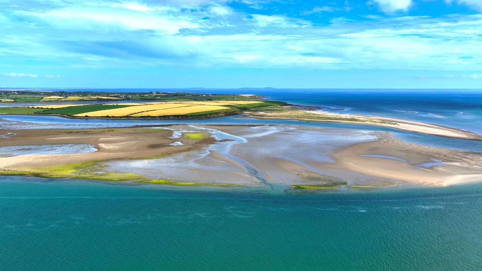 Beautiful view of coastal farmland with open field edges and surrounding green fields, Wonders of the World Pictures.
