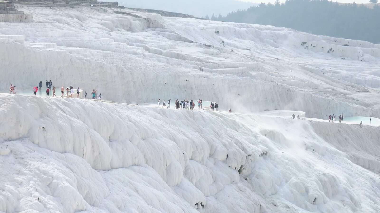 People are walking along the edge of a huge waterfall, enjoying the amazing view, Wonders of the World Pictures.
