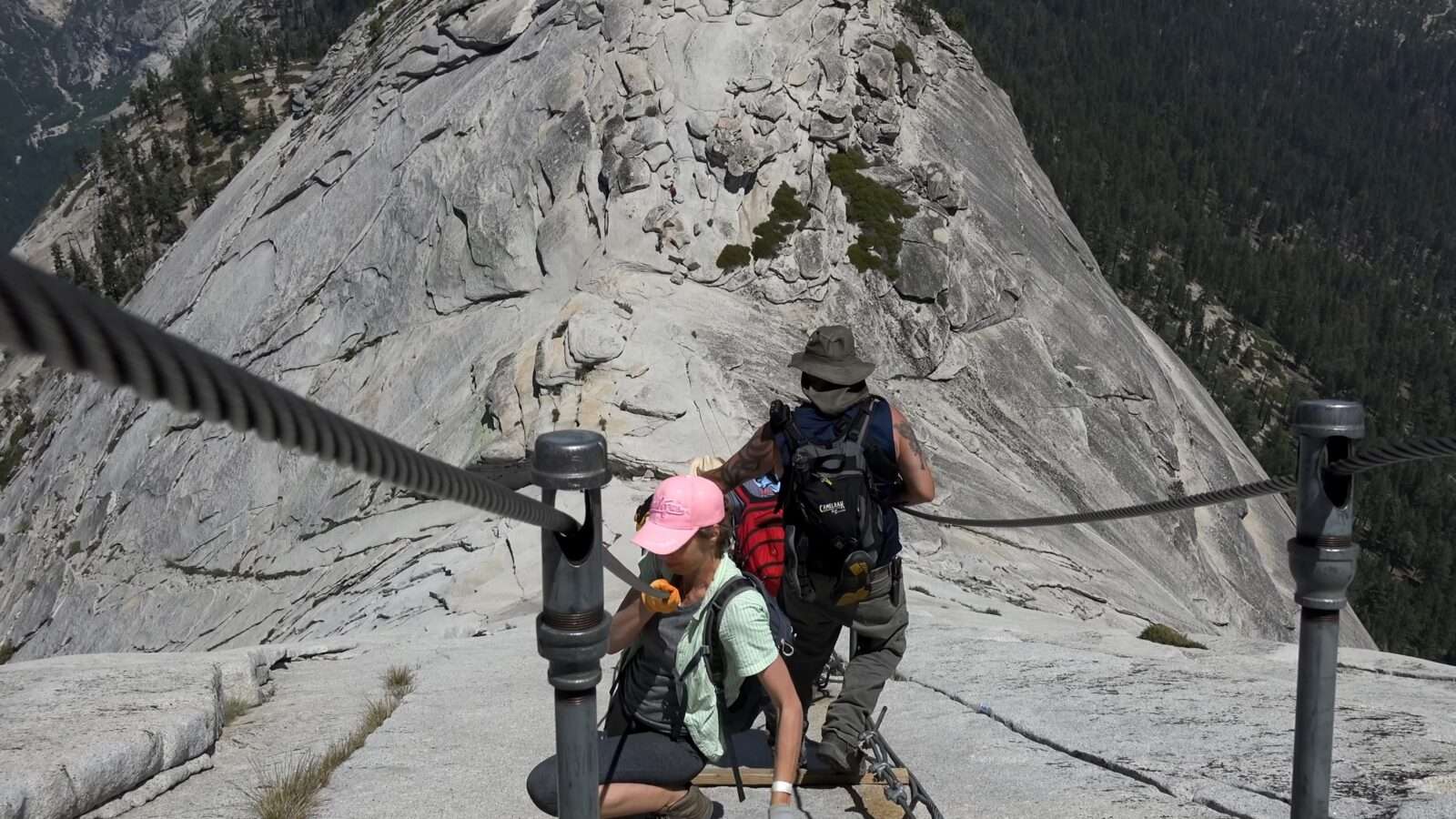 Two people are climbing a mountain walking on a rope, an amazing display of courage and balance, Wonders of the World Pictures.