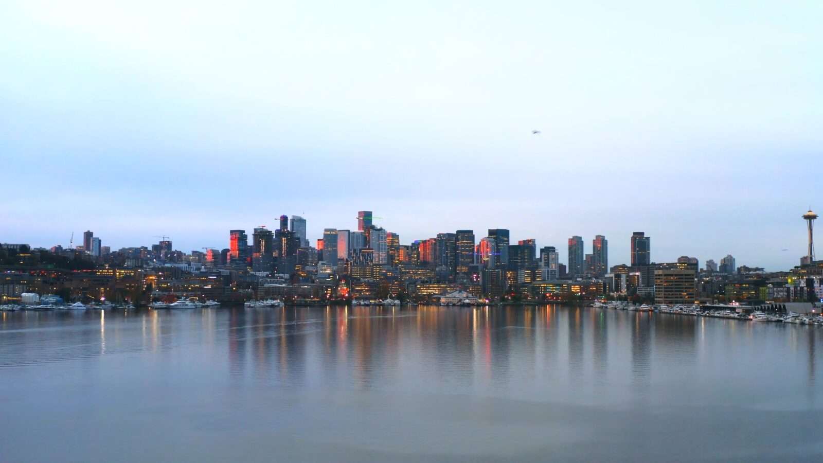 View of the city at dusk, with sleeping buildings and embankment, iconic tower on the right, Wonders of the World Pictures.
