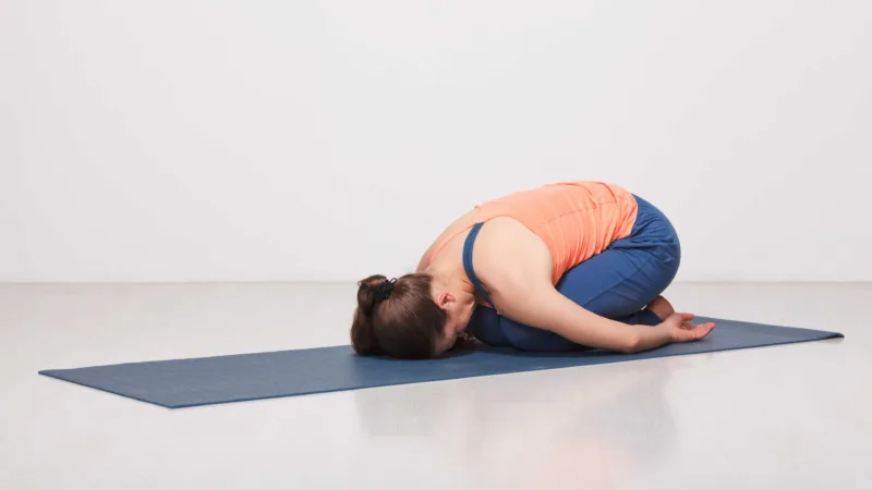 Girl Practices Yoga Asana Balasana