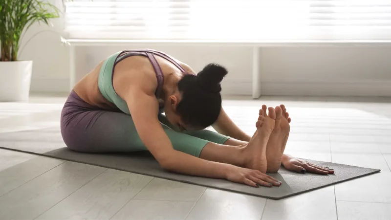 Woman Practicing Seated Forward Bend Asana