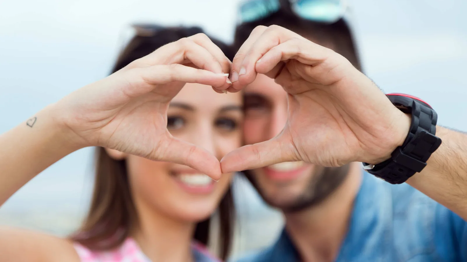 Love couple making heart shape with their hands