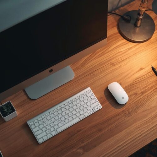Modern computer workstation on a wooden desk with warm lighting – stylish 4K Cool Wallpaper