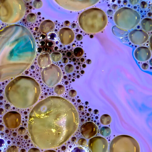 Oil and water bubble macro abstract 4K wallpaper with golden and purple tones